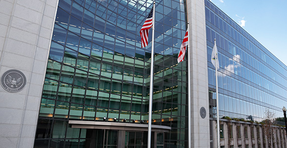 American flags wave in front of a corporate building.