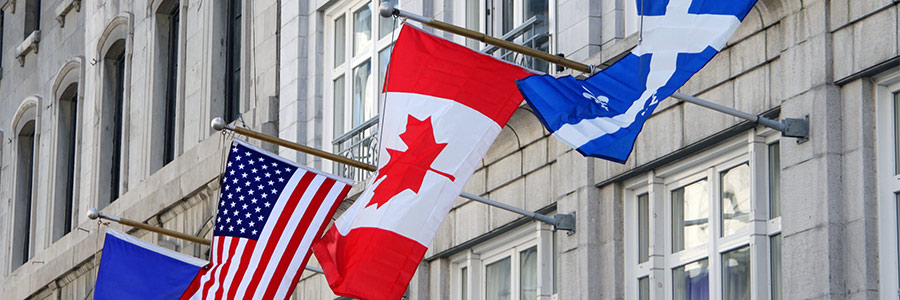 Flags on a building representing E.U., U.S., Canada and Quebec