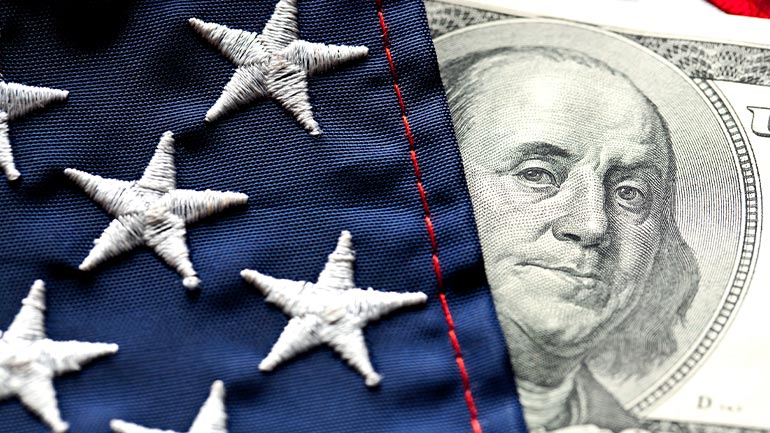 Closeup of a U.S. flag and $100 bill