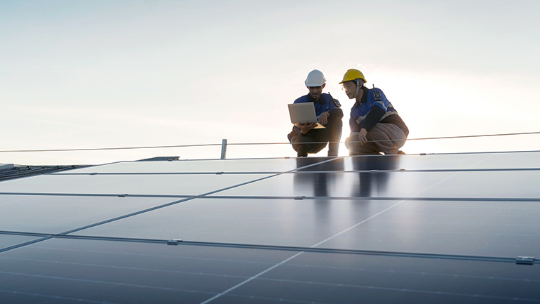 Deux ingénieurs sur un toit à panneaux solaires
