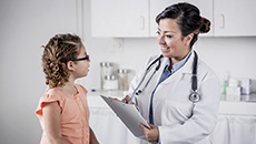 A doctor chats with a young patient.