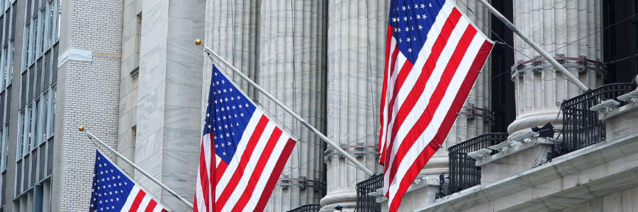 U.S. flags displayed on the exterior of a large office building.