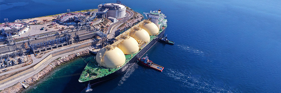 A large liquefied natural gas tanker docked at a coastal terminal.