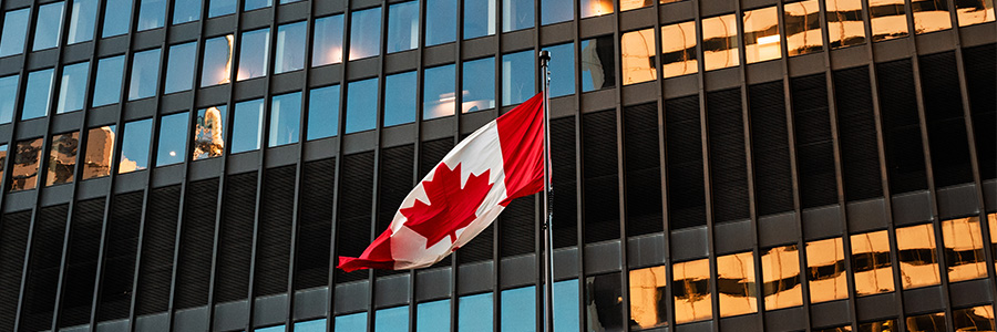 Canadian flag flying outside an office building.