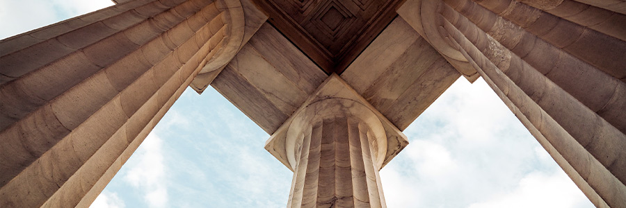 Stone columns viewed from below, supporting a classical-style structure.