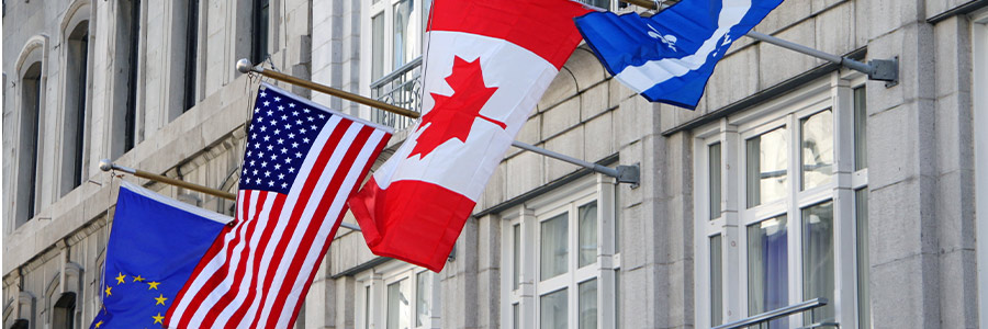 Drapeaux de l’Union européenne, des États-Unis et du Canada flottant à l’extérieur d’un immeuble de bureaux 