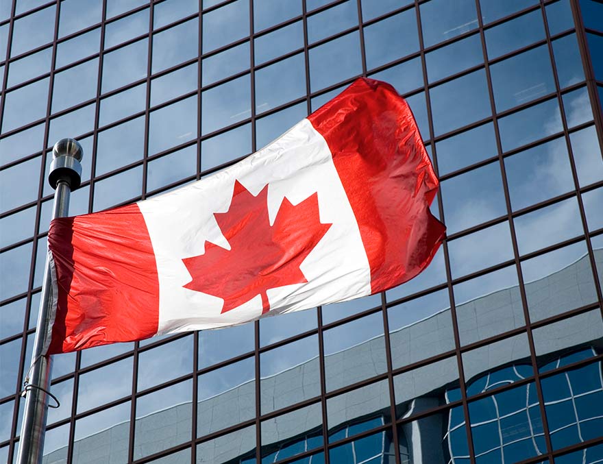Drapeau canadien claquant au vent devant l’immeuble d’une société