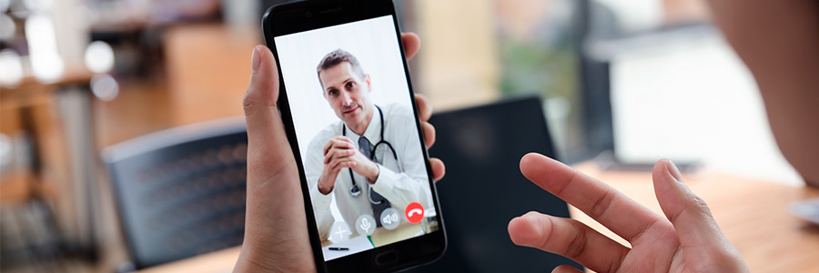 Une personne qui utilise son téléphone intelligent pour faire un appel vidéo avec son médecin.