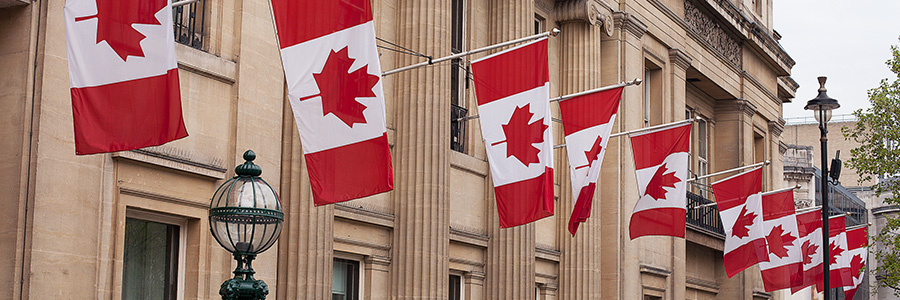 Government building with several Canadian flags flying.