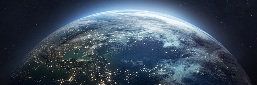 View of Earth from space showing illuminated land and clouds.