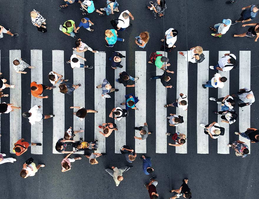 Top-down view of people walking on a street crosswalk