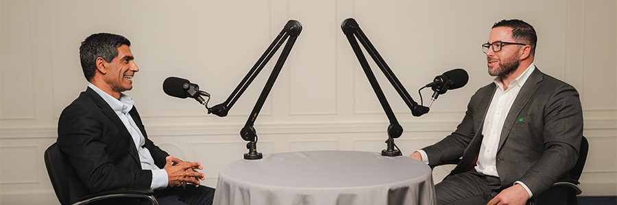 Omar Hayat and Aaron Bilkoski speaking into a microphones during the podcast recording.