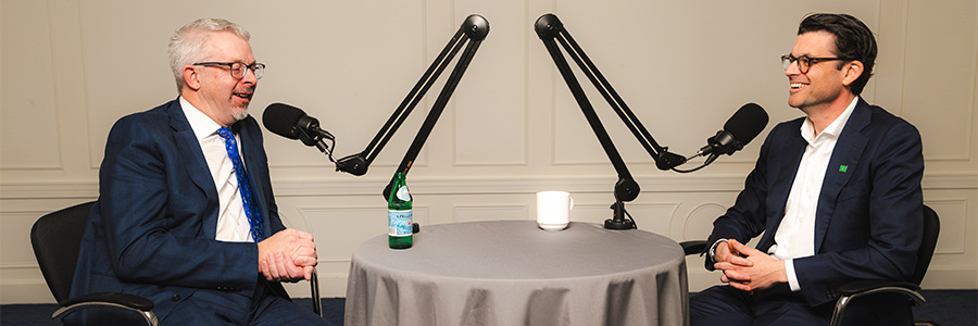 David Spyker and Aaron Bilkoski speak into microphones while recording podcast.