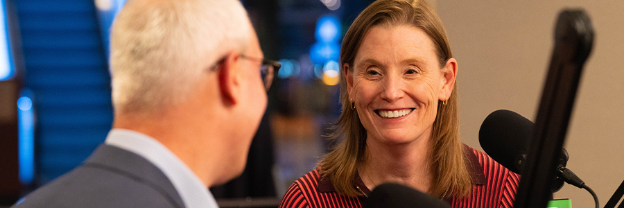 Podcast studio setup with Yaron Werber and Amy Burroughs seated at microphones during a recorded discussion.