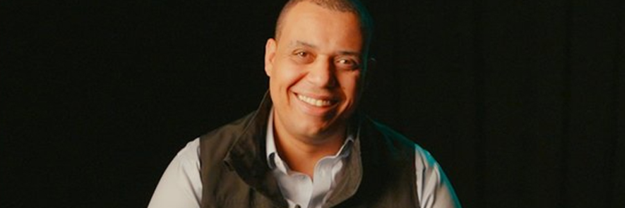 Person wearing a TD-branded vest against a dark background.