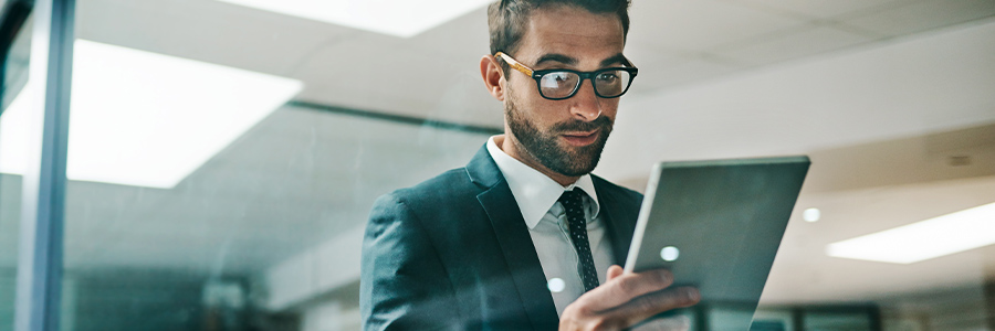 Person in business attire using a tablet in an office setting.