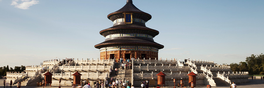 Temple of Heaven in Beijing with visitors on a wide stone terrace under clear sky.