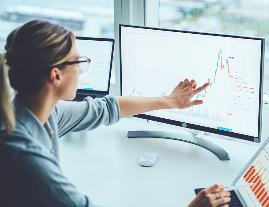 Business woman analyzing a financial chart on a computer screen