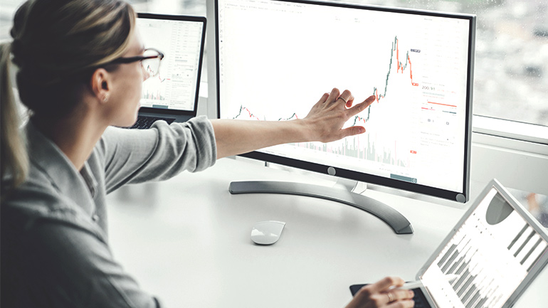 A woman reviews investment information on her computer