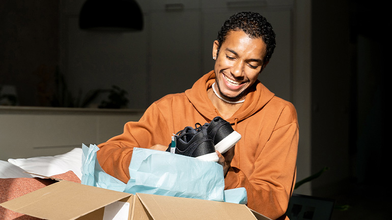 Person opening a box with new sneakers inside.