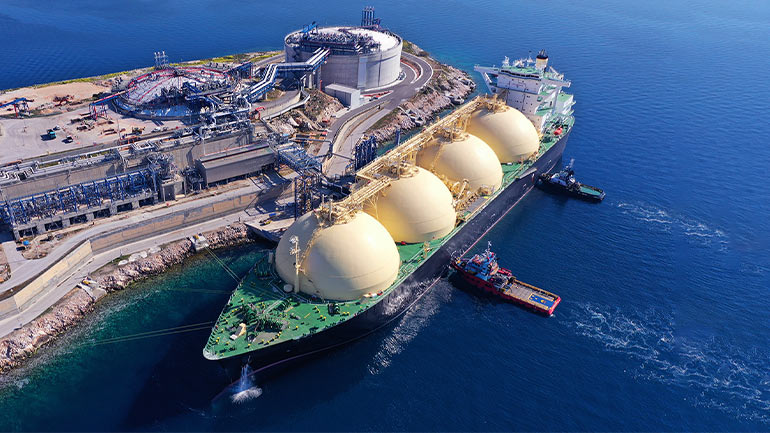 Un grand pétrolier transportant du gaz naturel liquéfié amarré à un terminal côtier.