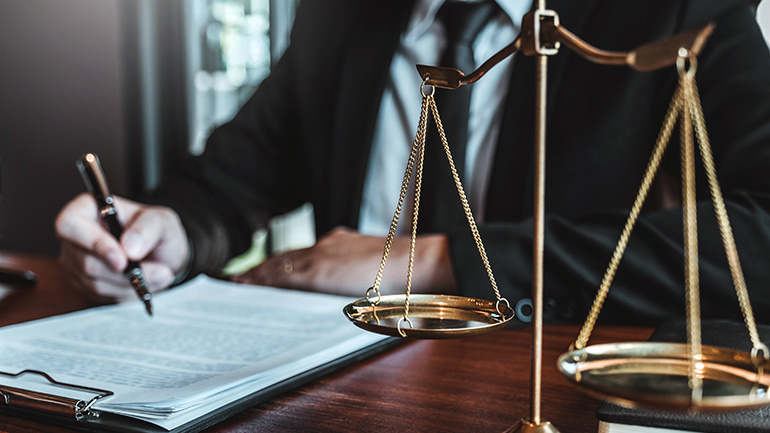 A balance scale on the desk of a businessperson