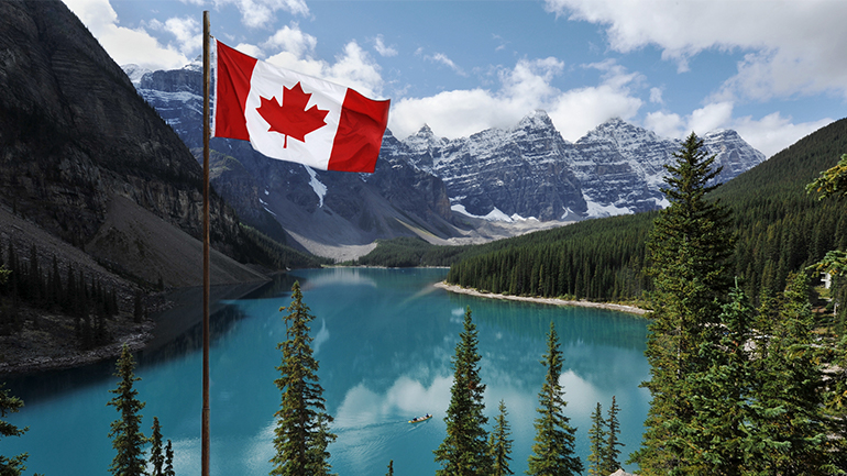 Canadian flag with the Rocky Mountains in the background