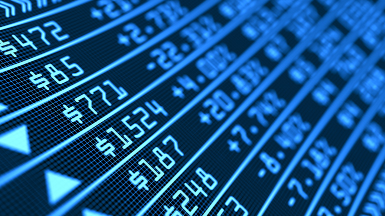 Macro close up image of a digital stock market board showing blue numbers and prices.