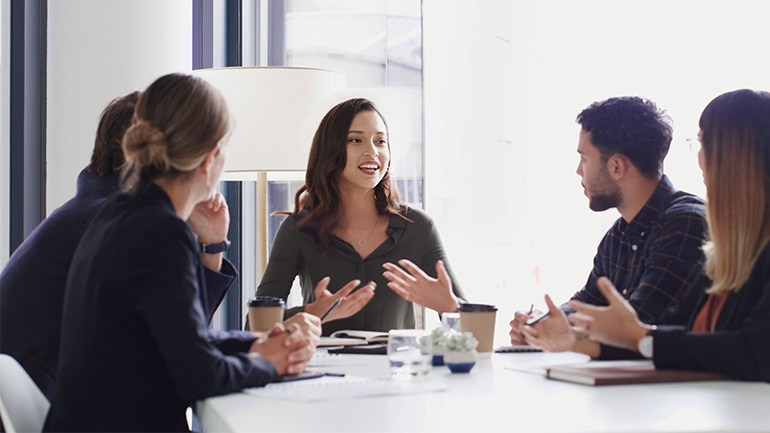 A woman leader addresses her team during a meeting. 