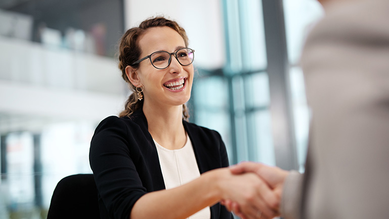 A business woman shakes hands with a colleague.