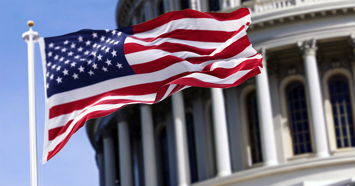Close up of and American flag waving in front of the U.S. Capitol building in Washington D.C.