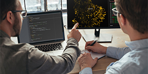 Two older people in a warehouse looking at a tablet computer.