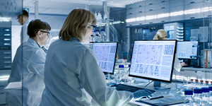Ground view looking up at a worker on top of a warehouse roof under construction.